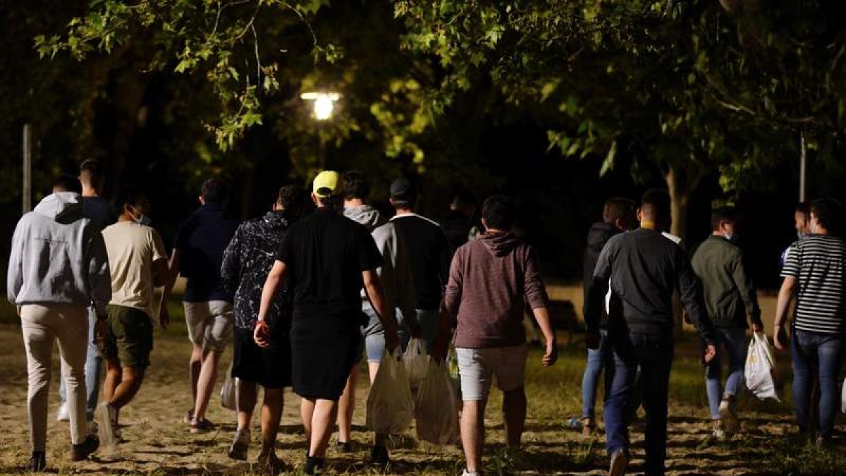 Un grupo de jóvenes con bolsas llenas de botellas para hacer un botellón. NACHO GALLEGO