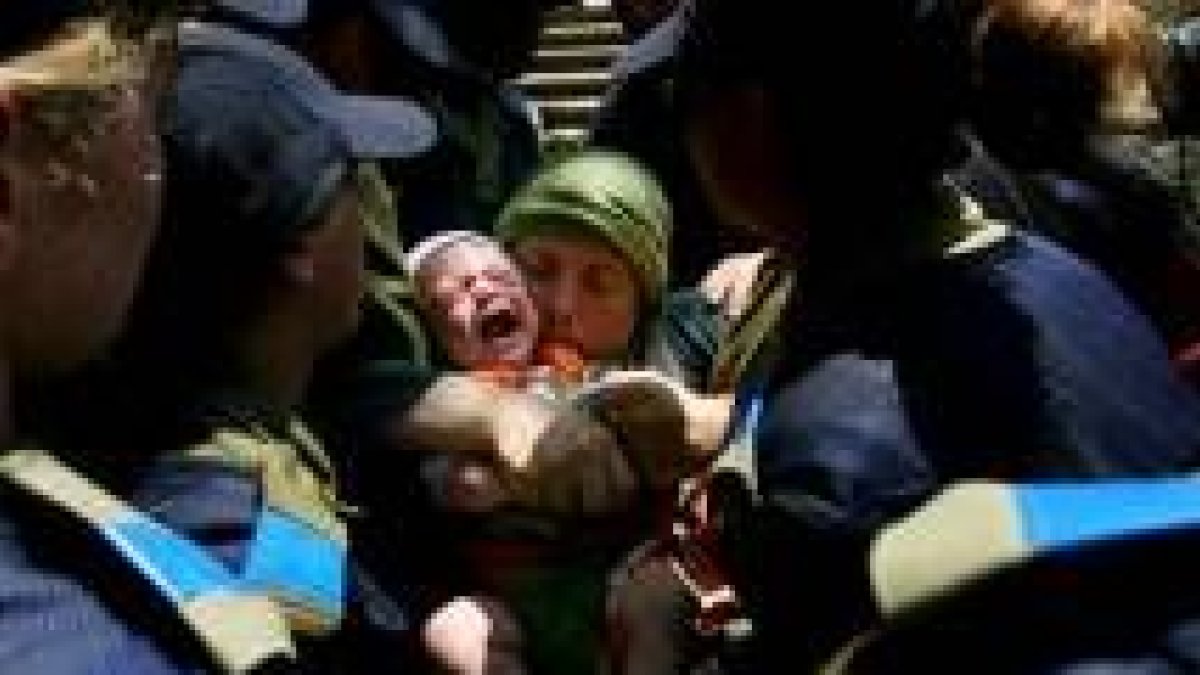 Una mujer y su bebé son desalojados por soldados israelíes del asentamiento de Homesh