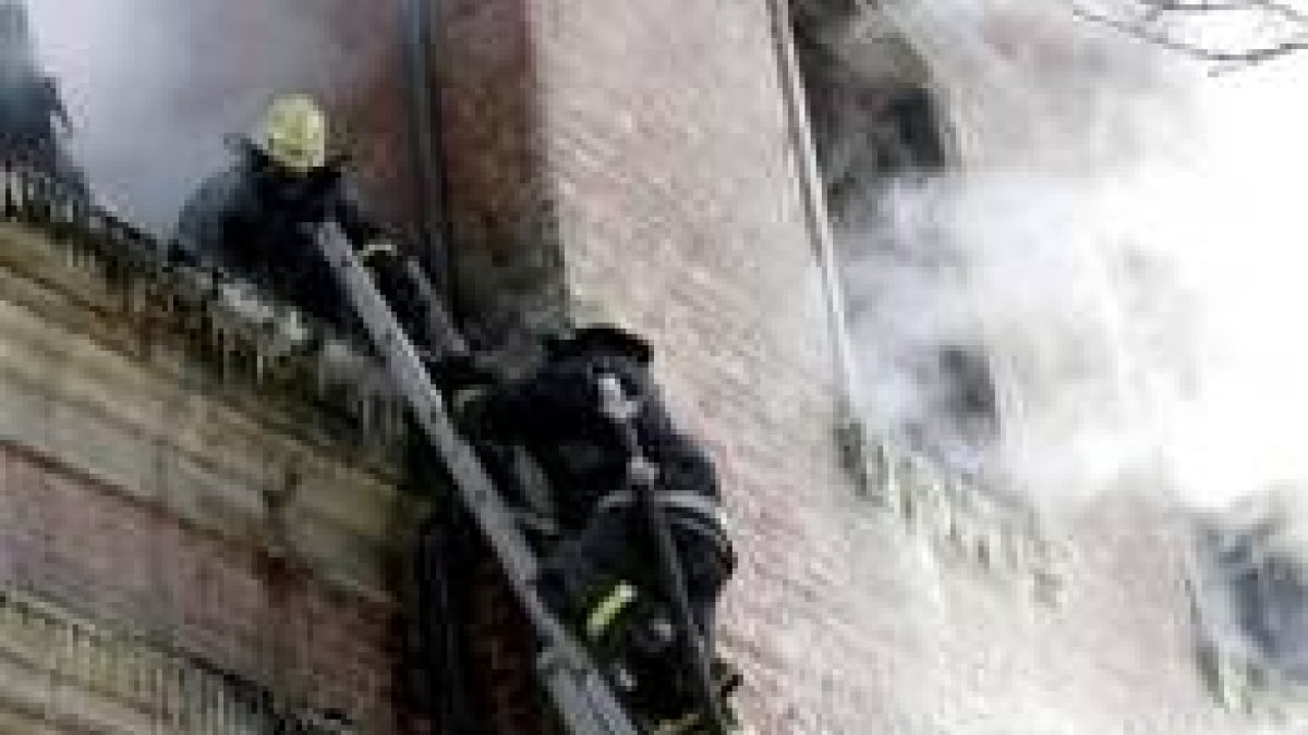 Dos bomberos durante la extinción del incendio en la residencia de la ciudad letona de Alsunga