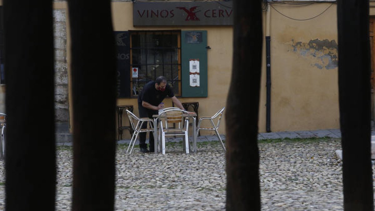 Un camarero limpia la mesa de una terraza de la Plaza del Grano. FERNANDO OTERO