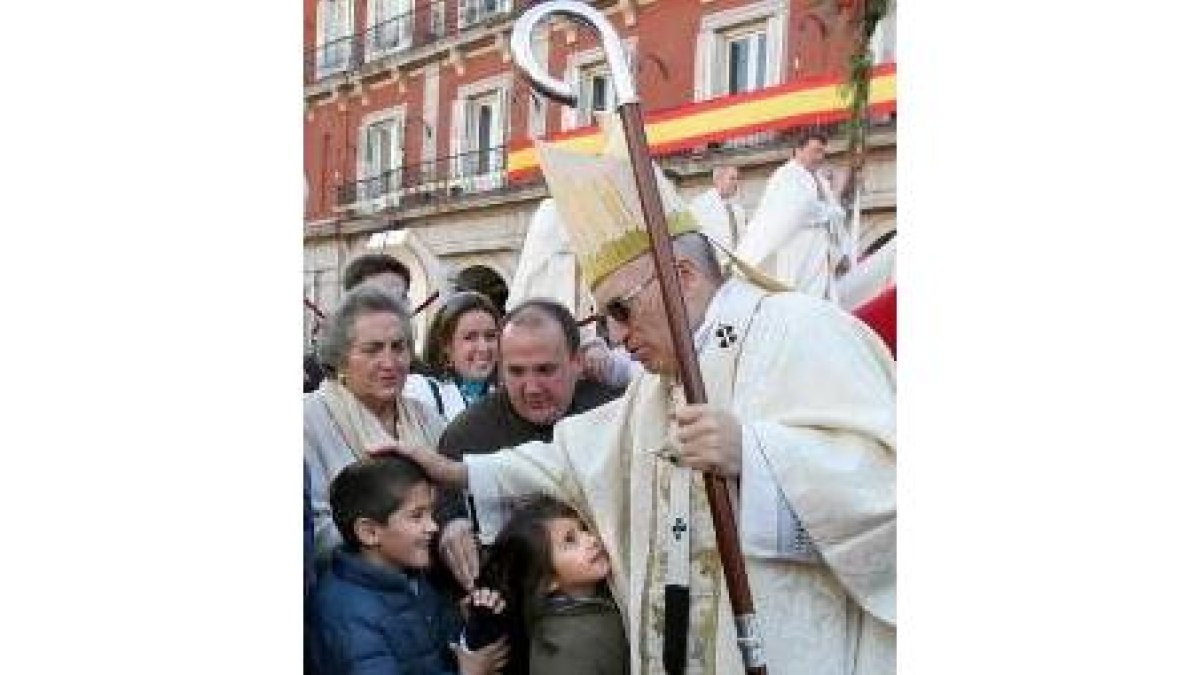 Rouco Varela acaricia a unos niños, ayer tras la celebración de la misa