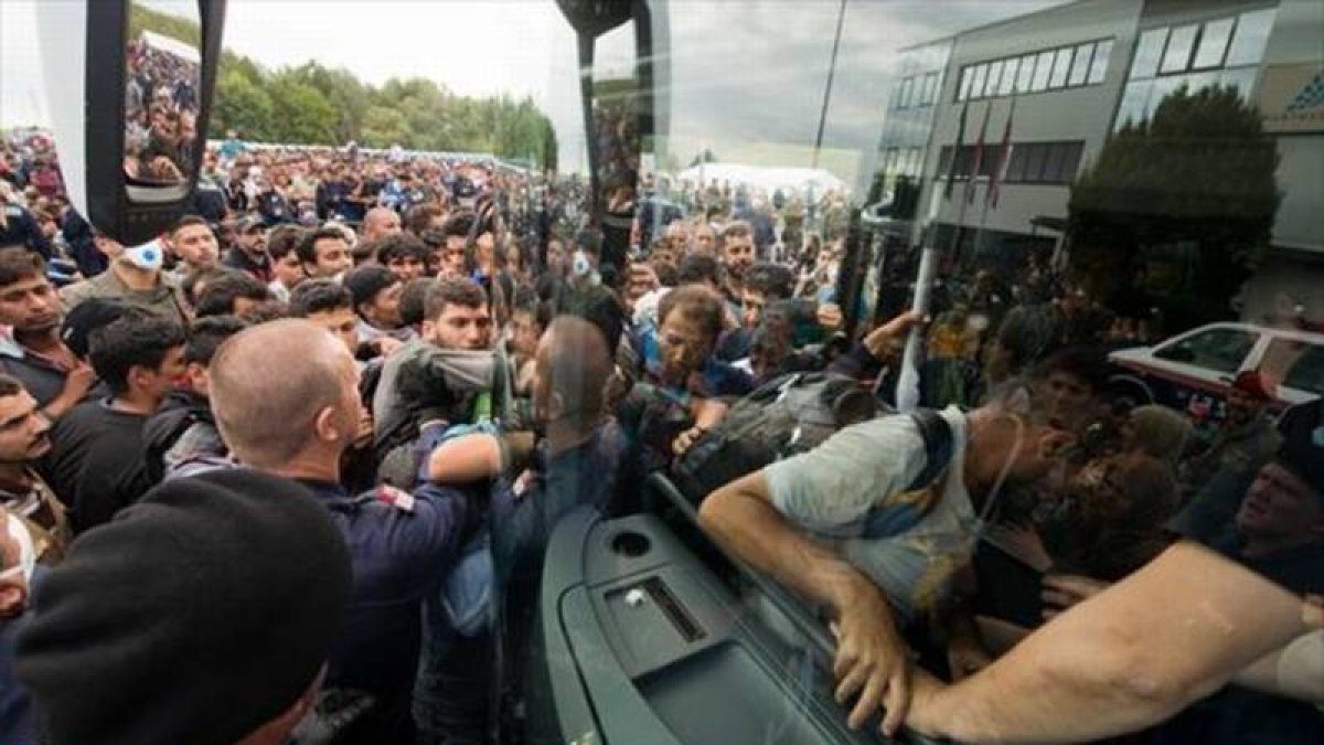 Refugiados suben a un autocar cerca de Heiligenkreuz, en la frontera entre Austria y Hungría, ayer.