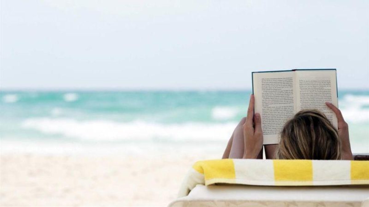 Un trabajador leyendo un libro disfrutando de las vacaciones.