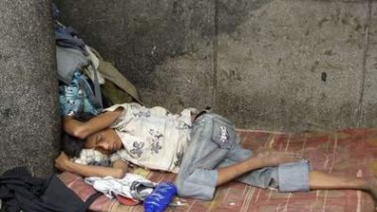 Un niño sin hogar dormita en un rincón de Phnom Penh, Camboya, al amanecer.