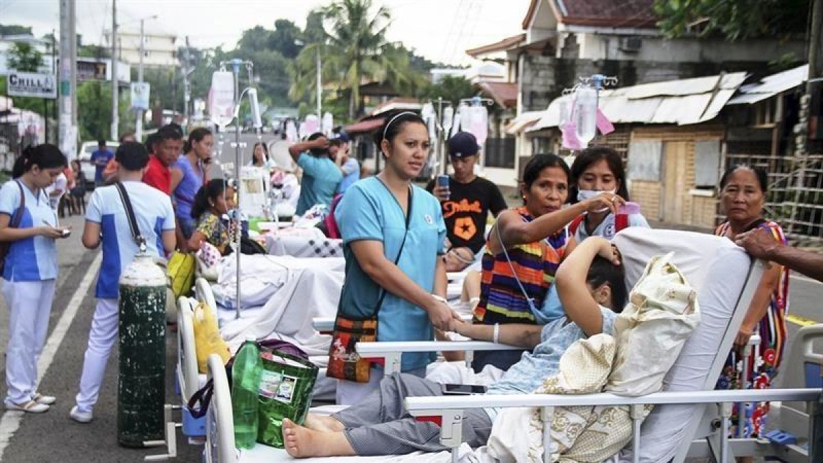 Pacientes y enfermeras permanecen en la calle a las puertas de un centro de evacuación tras un terremoto de 5,1 grados en la escala Ritcher en la isla de Leyte (Filipinas).