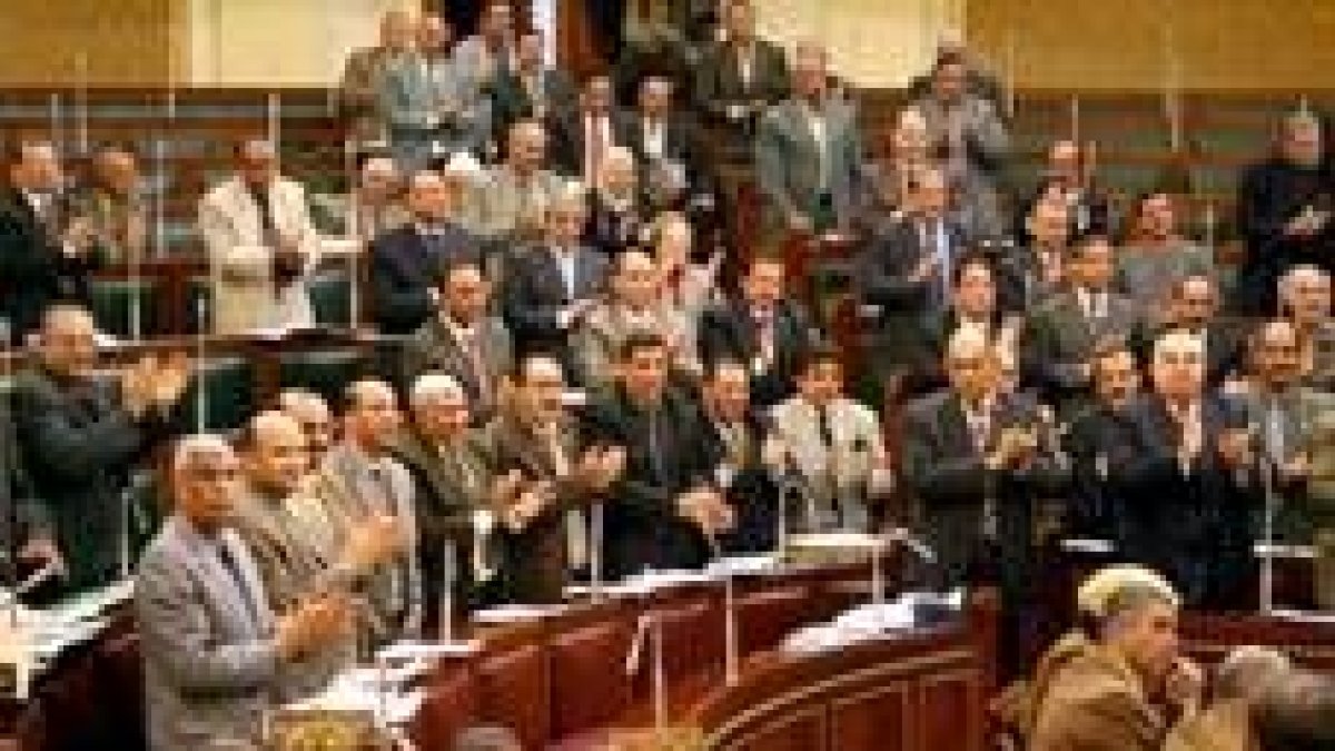 Diputados egipcios aplauden de pie en el Parlamento tras conocer las reformas que prepara Mubarak