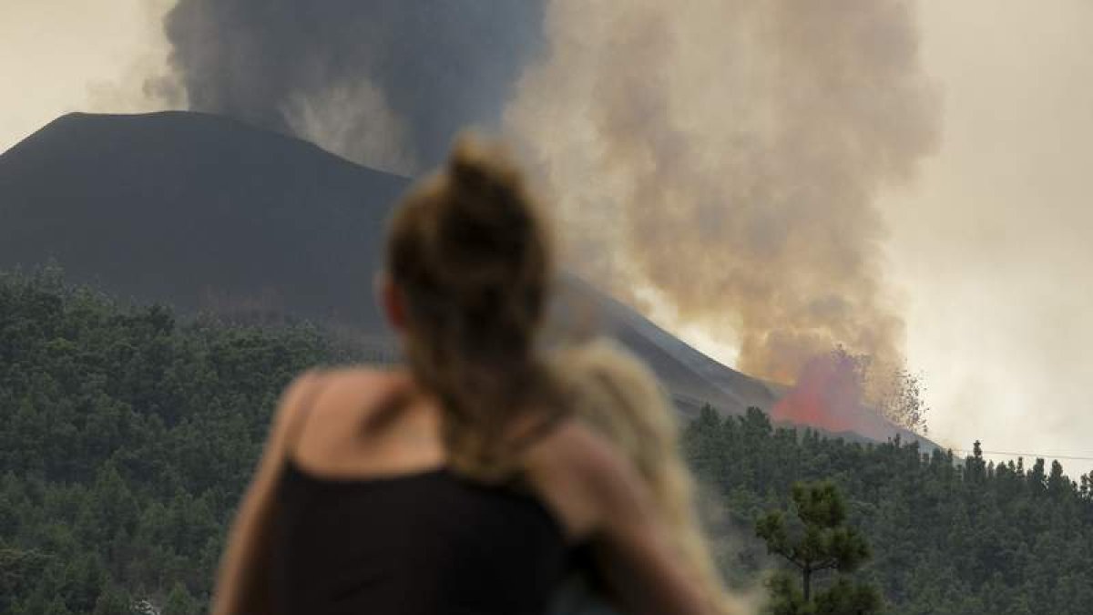 Una mujer abraza a su hija mientras contemplan el volcán en La Palma. ÁNGEL MEDINA