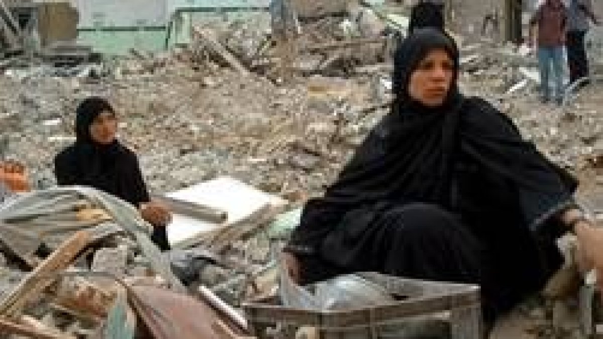 Dos palestinas se sientan sobre los restos de lo que fue su casa en Rafá
