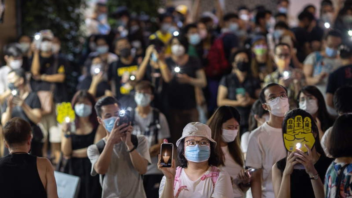 Ciudadanos de Hong Kong encienden ayer velas y móviles. JEROME FAVRE