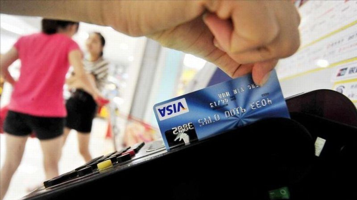 Una mujer usa su tarjeta de crédito.