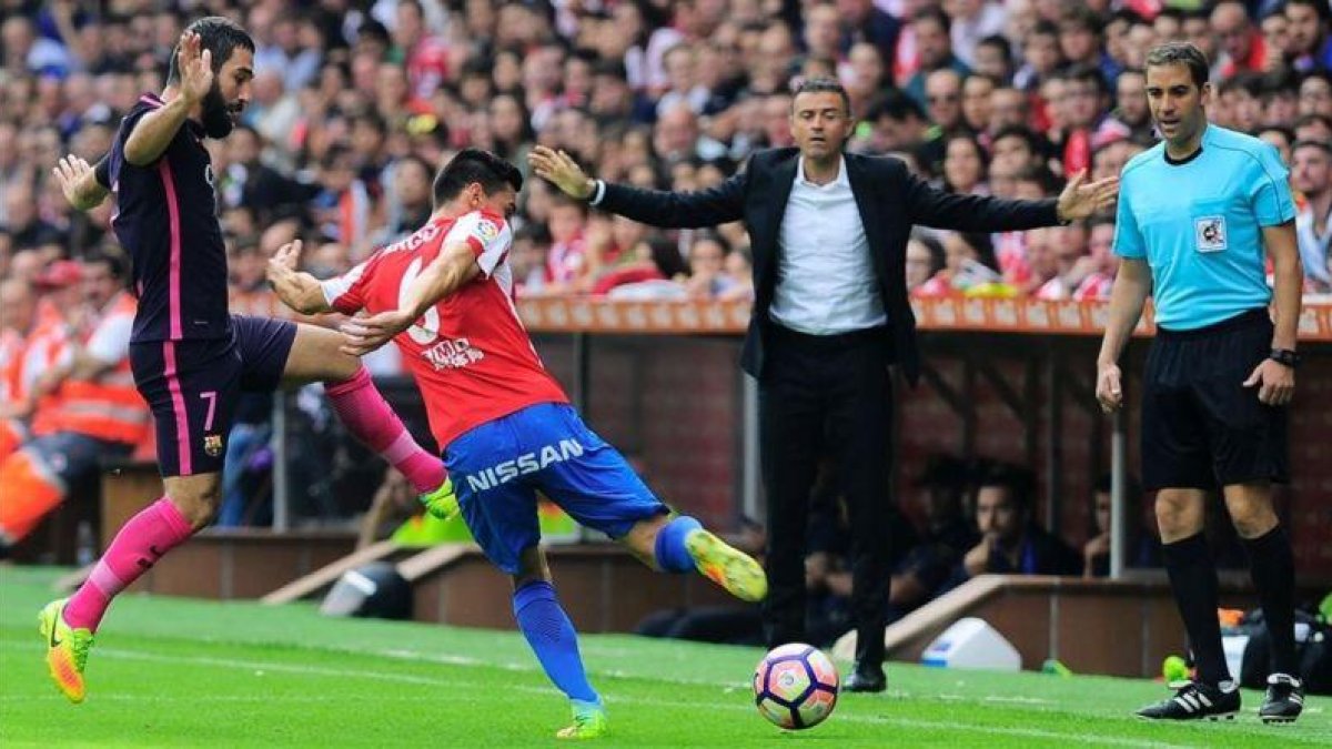 Arda Turan y Sergio Álvarez luchan por un balón delante de Luis Enrique en El Molinón.