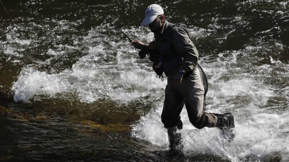 Un pescador en un río leonés