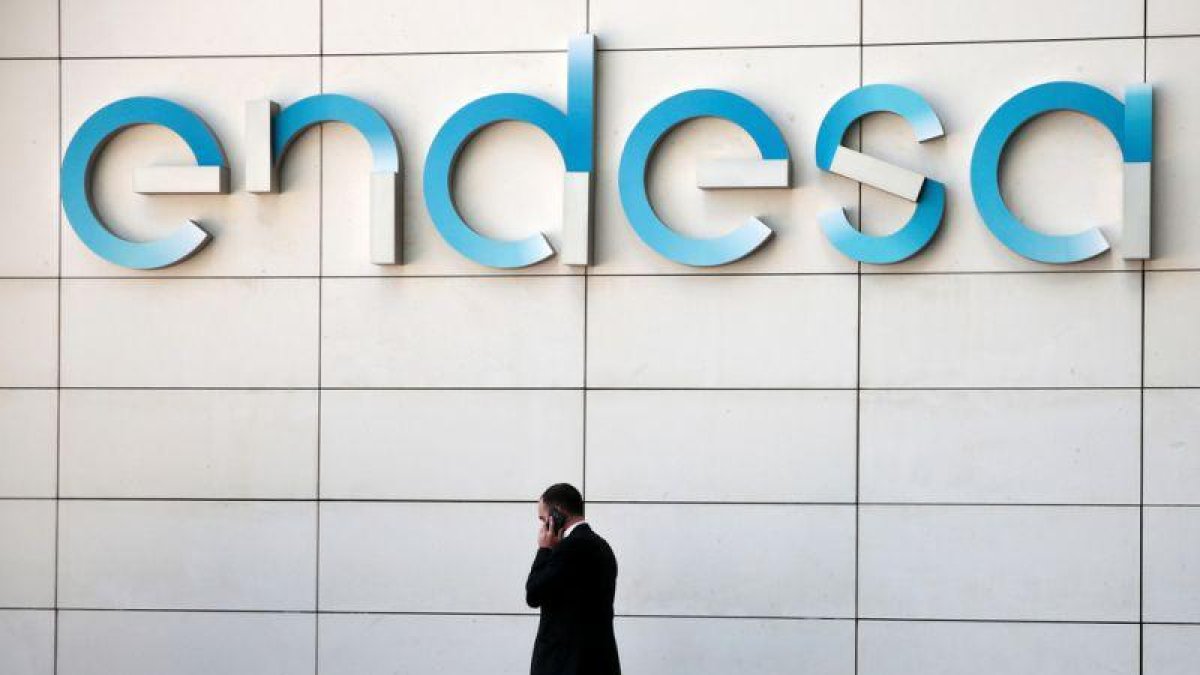 Un hombre camina bajo el logo de Endesa en la sede de la empresa en Madrid.