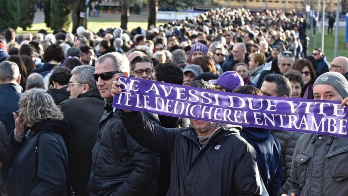 Un aficionado sostiene una bufanda de la Fiorentina durante el funeral de Davide Astori