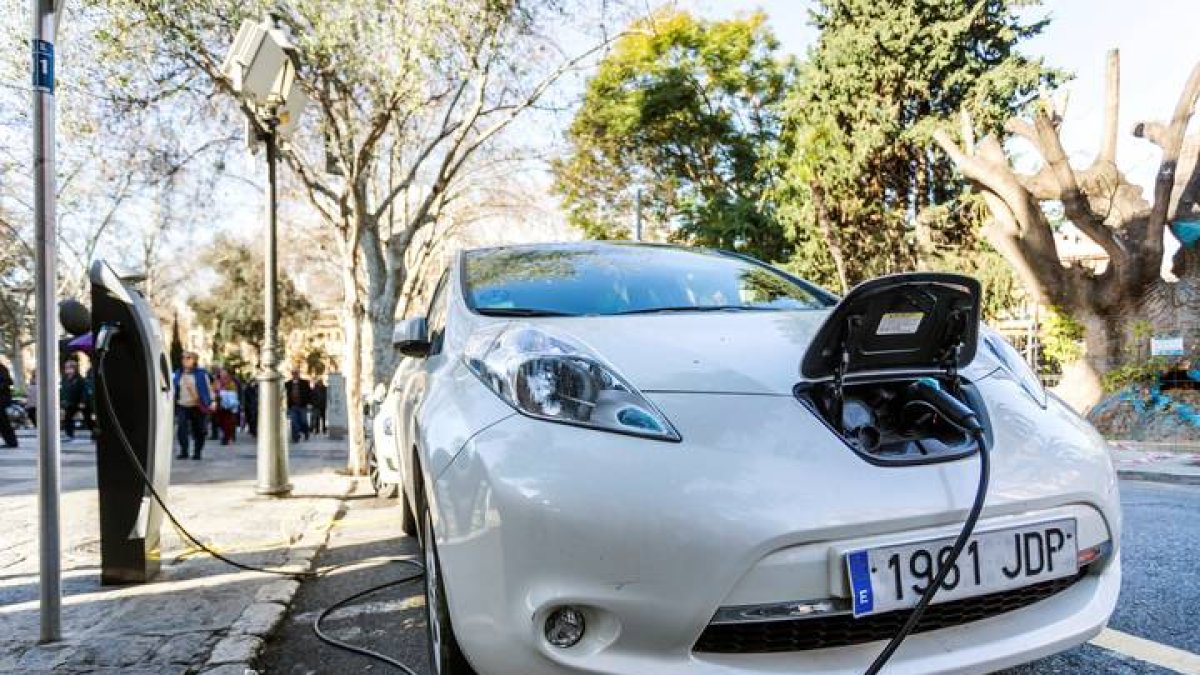 Vista de un coche eléctrico mientras carga la batería en el centro de Palma de Mallorca. LLITERES