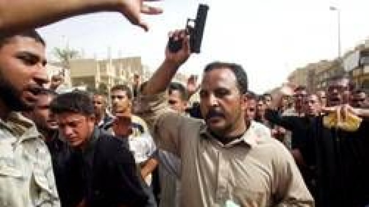 Un peregrino chií muestra su pistola tras los ataques contra la multitud de fieles
