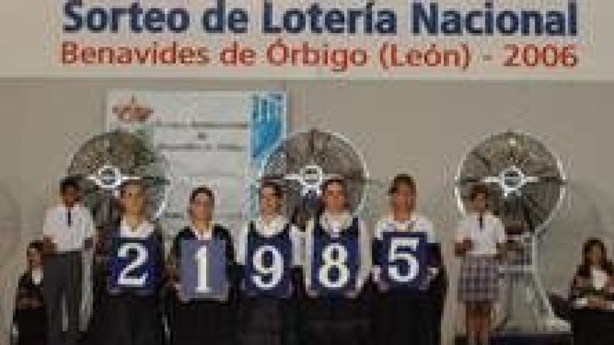 Unas jóvenes con trajes regionales muestran el número premiado en el sorteo de Benavides