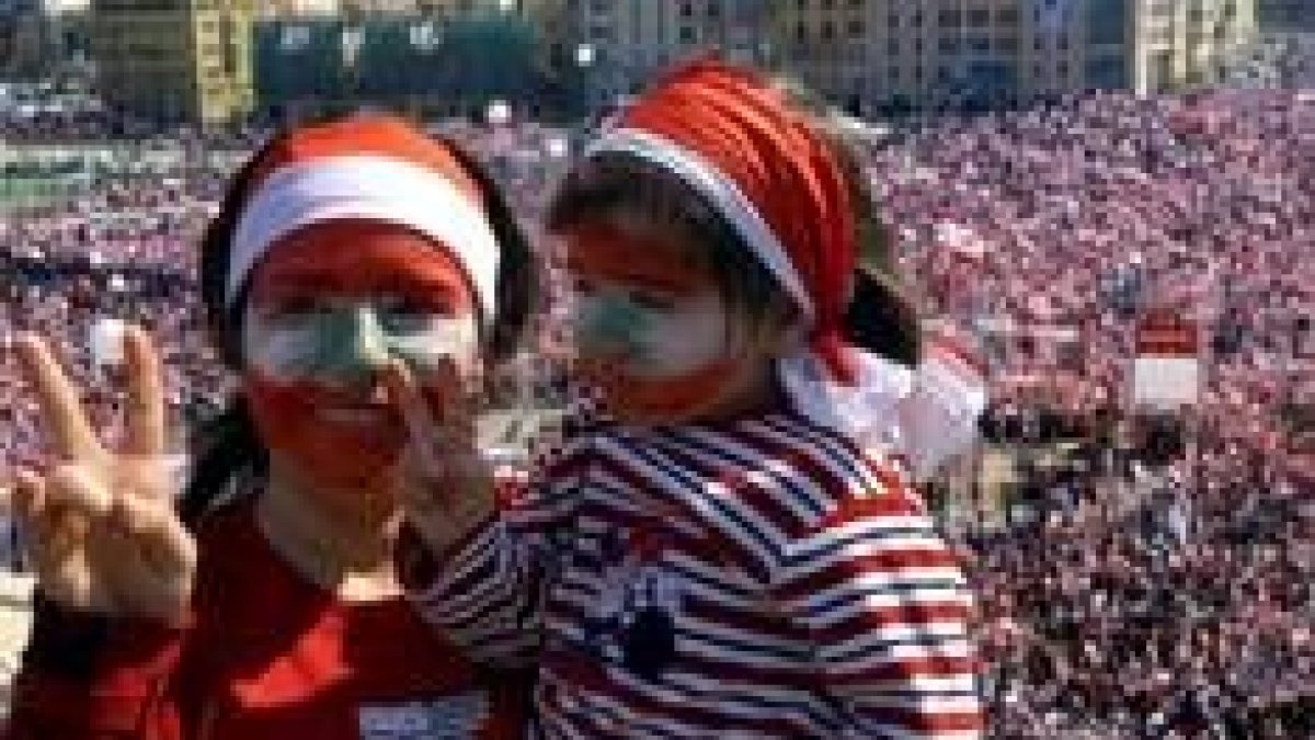 Una mujer y su hija pequeña hacen la señal de la victoria en la macromanifestación de Beirut
