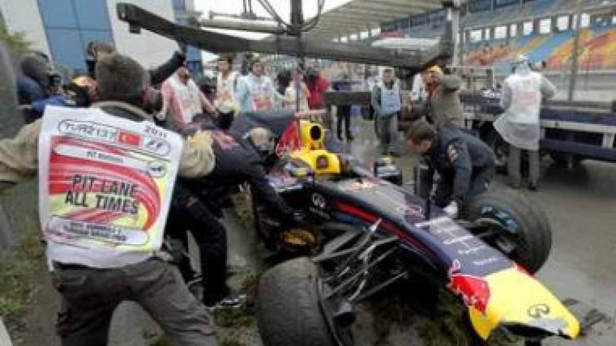 Trabajadores del circuito retiran el coche de Vettel.