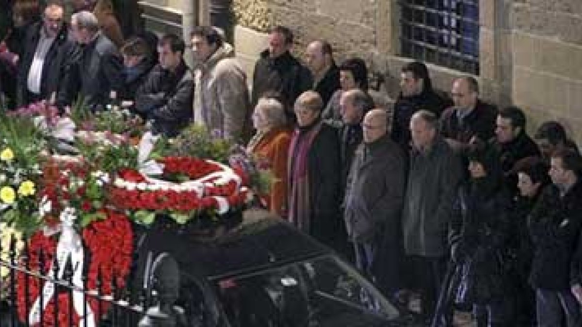 Vecinos de Azpeitia observan la llegada del coche fúnebre con los restos de Ignacio Uria.