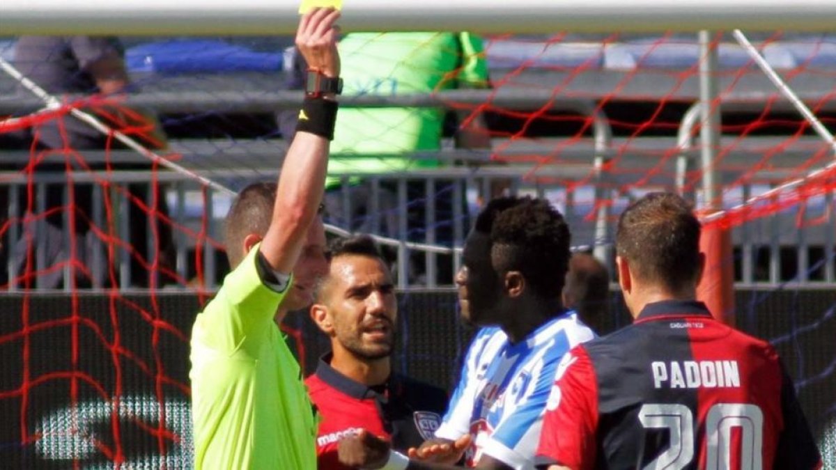 El árbitro Daniele Minelli saca la tarjeta amarilla a Muntari durante el Cagliari-Pescara del domingo.