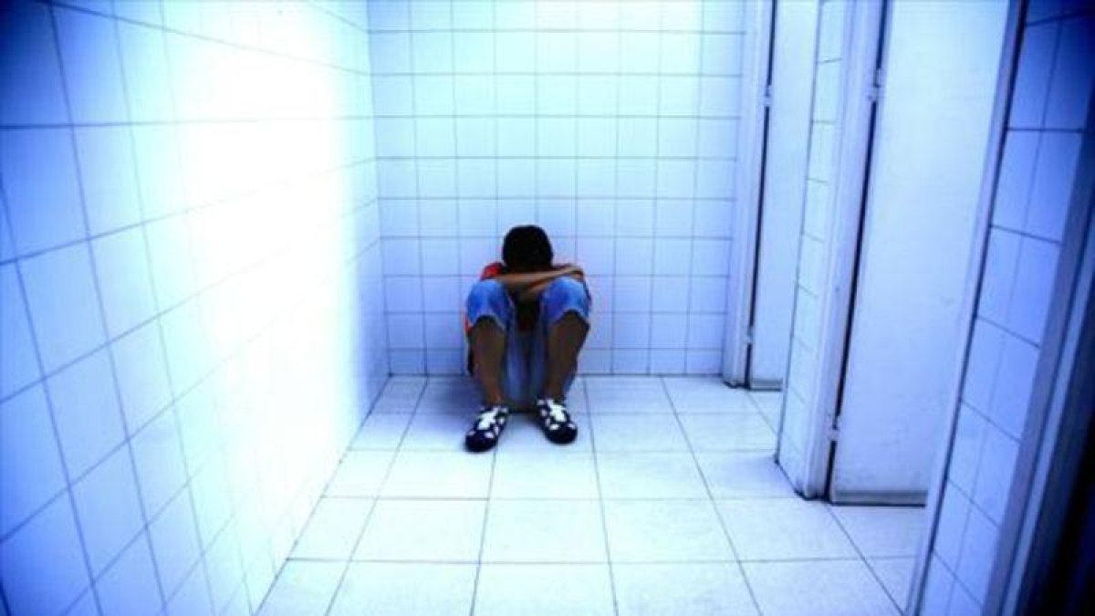 Un joven, víctima de acoso escolar, se refugia en un lavabo.