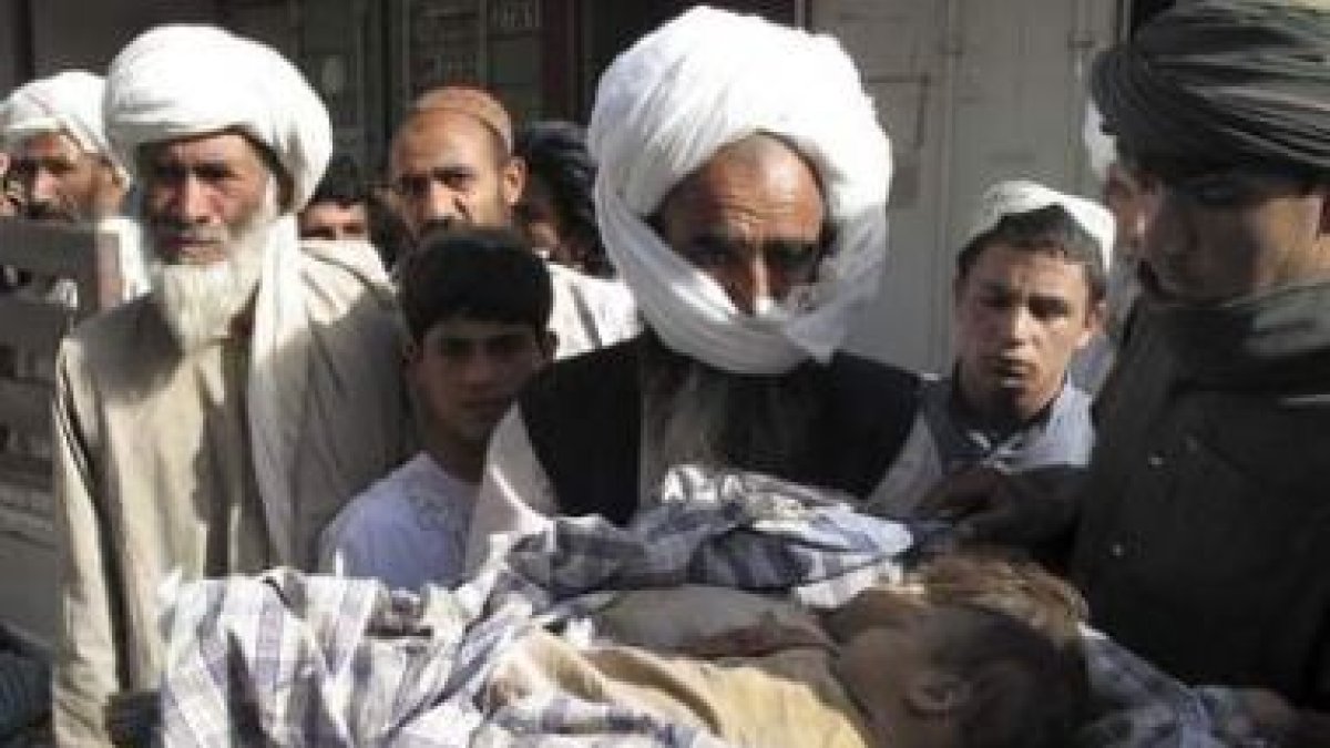 Familiares sujetan los cuerpos de dos niños fallecidos durante un bombardeo de la Otan.