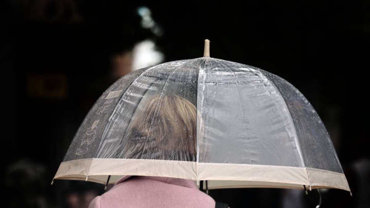 Una mujer se protege de la lluvia con un paraguas. ANA ESCOBAR