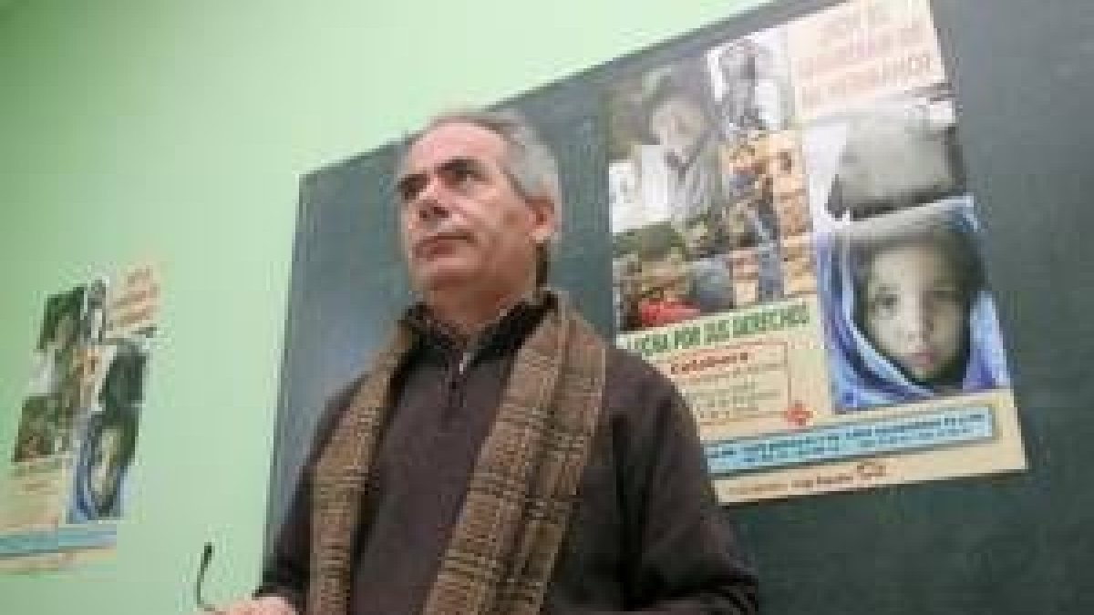 José Antonio Prada delante del cartel que anuncia la nueva campaña solidaria de Navidad de Cáritas