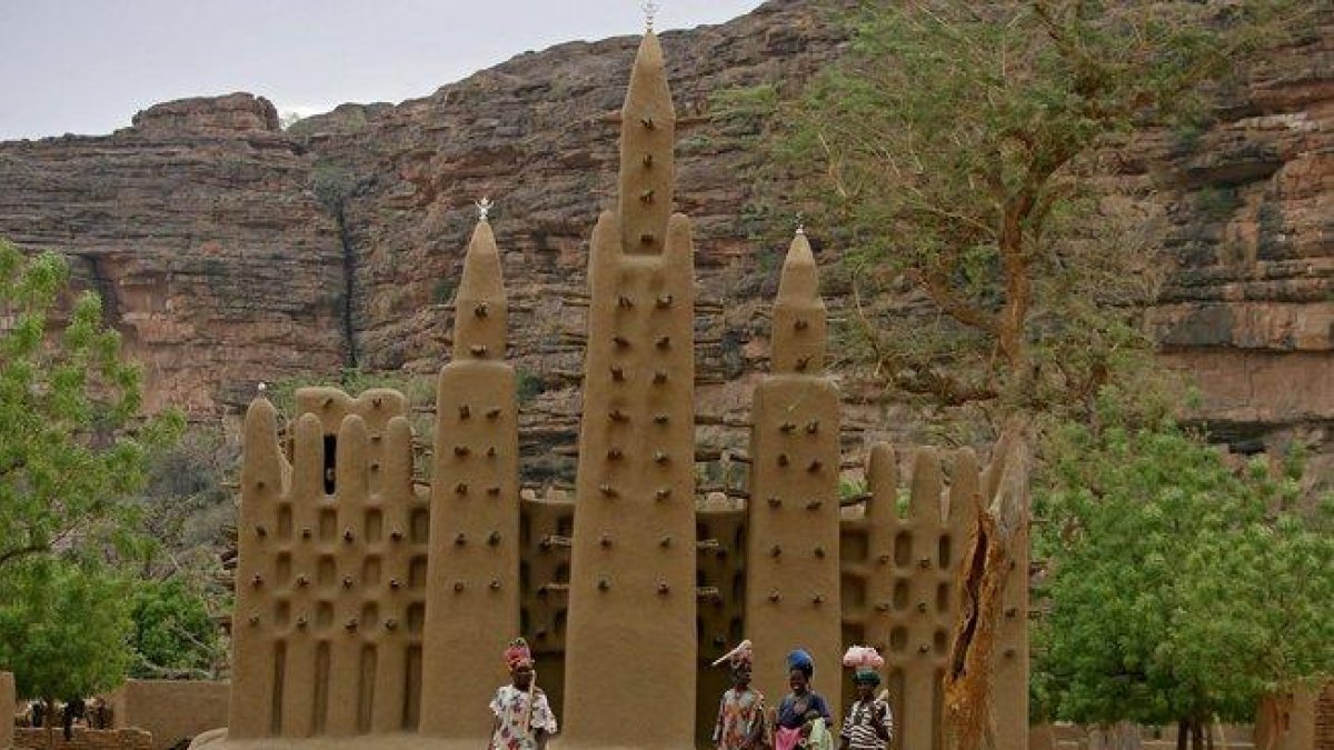 Varias mujeres pasan frente a una mezquita en una aldea dogon, en el centro de Mali.
