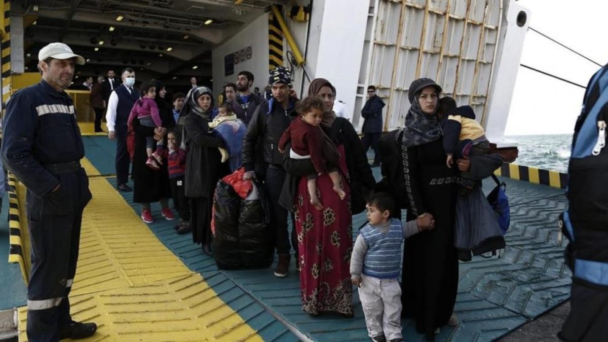 Refugiados y migrantes desembarcan del ferri 'Eleftherios Venizelos' a su llegada al puerto de Elefsina, a 20 kilómetros al noroeste de Atenas, procedentes de Lesbos, este lunes.