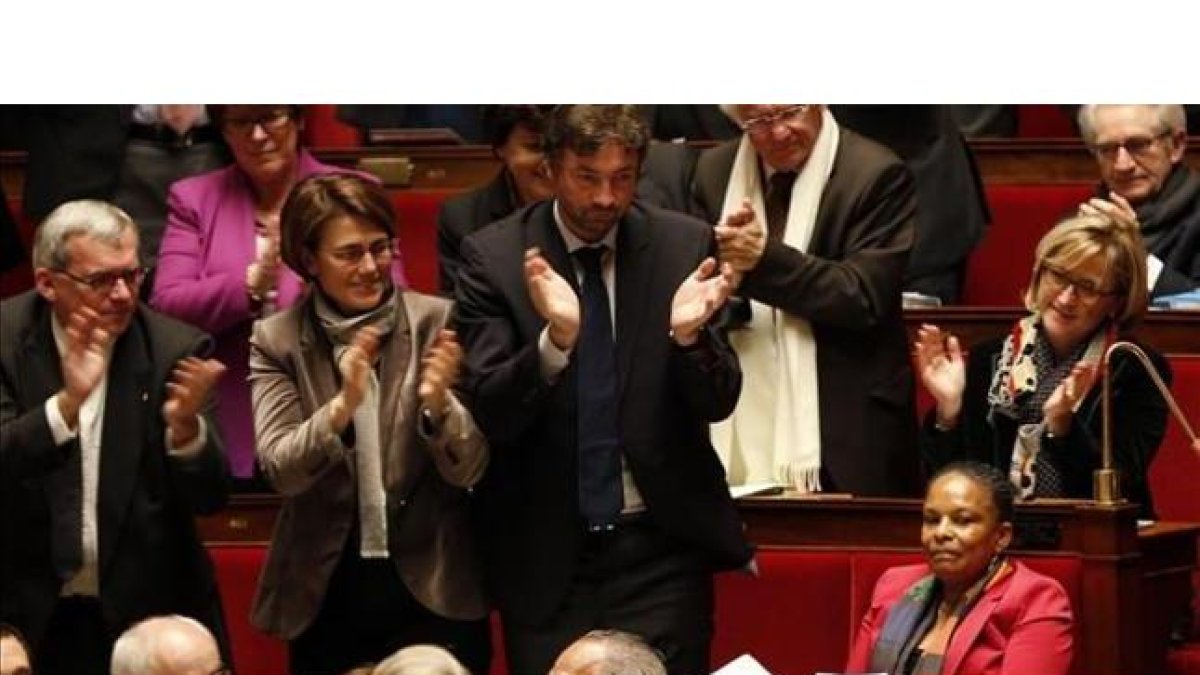 Diputados franceses aplauden a la ministra de Justicia, Christiane Taubira (derecha), antes de votar la ley, este martes en París.