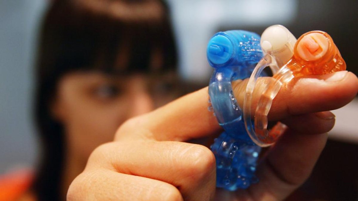 Una mujer muestra anillos vibradores, en una tienda de juguetes sexuales.