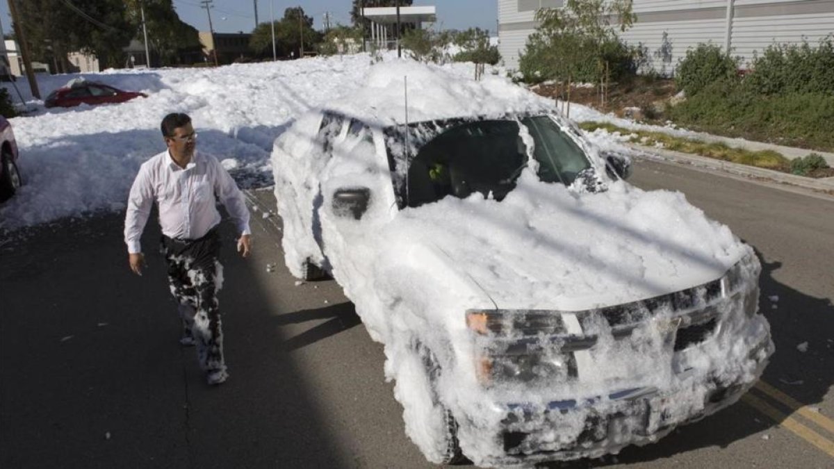 Un vecino observa su coche cubierto de espuma en San José (California).