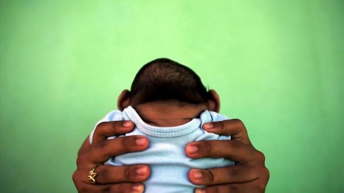 Jackeline sostiene a su hijo de 4 meses de edad y nacido con (Zika) microcefália frente a su casa en Olinda, cerca de Recife, Brasil, en una imagen de archivo.