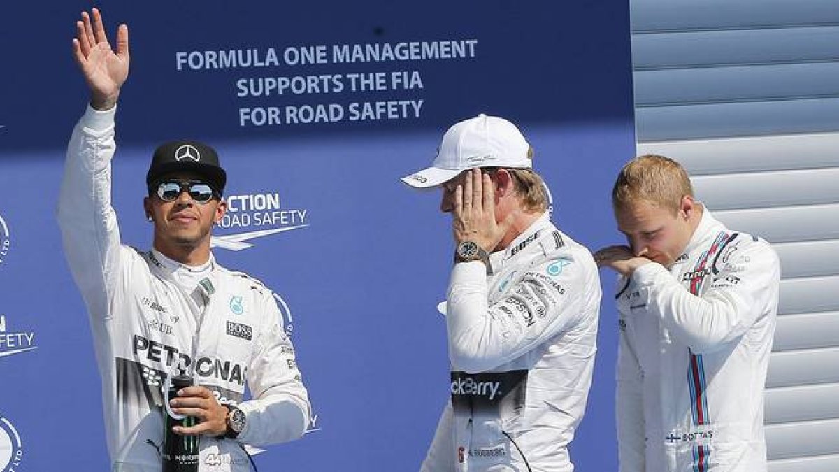 Lewis Hamilton, 'pole' en Spa, saluda a los aficionados junto a Nico Rosberg y Valtteri Bottas.
