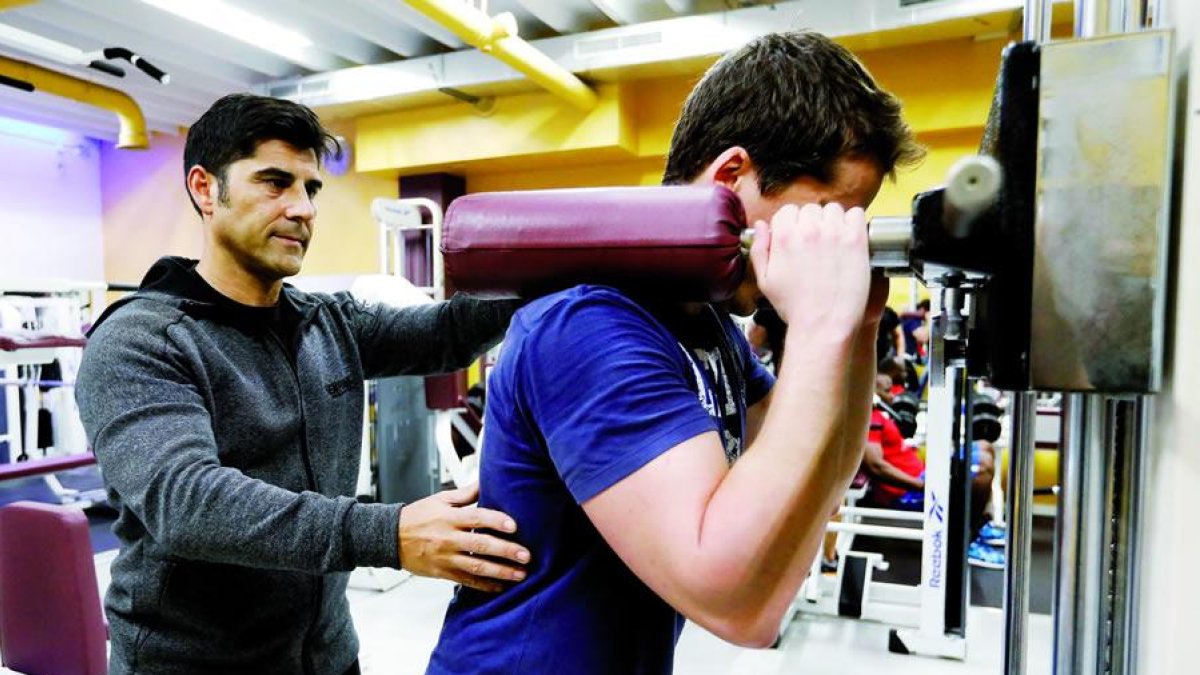 Arturo García indica a un joven como pujar protegiendo la espalda y la musculatura.