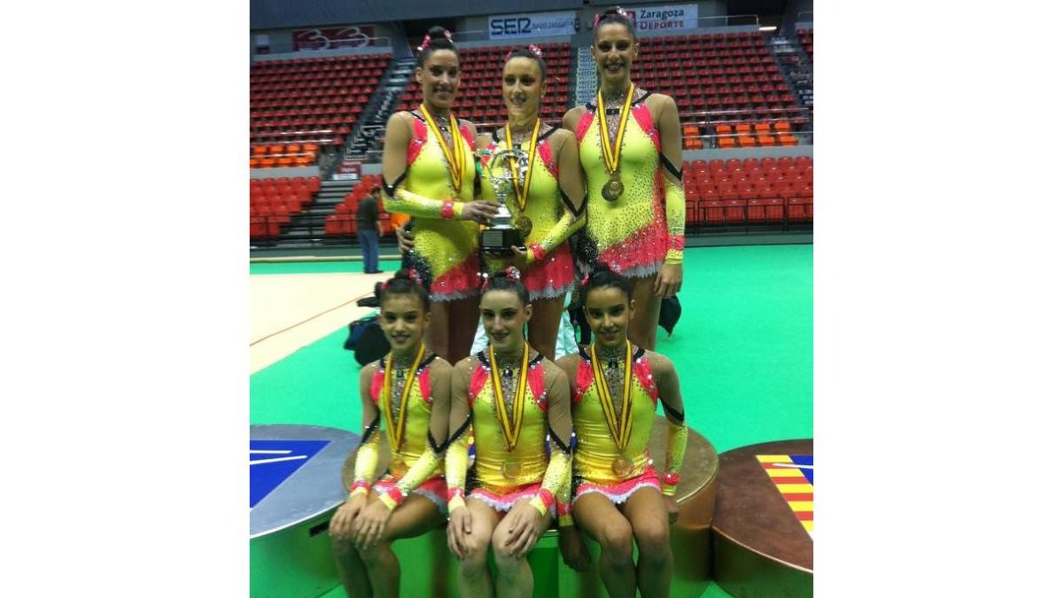 Las gimnastas del Ritmo posan en el podio con su medalla de oro.