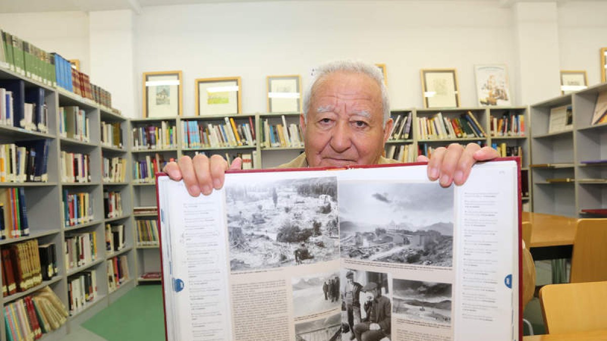 Benito Sierra en su rincón preferido de la biblioteca de Pinilla, con el libro «El Siglo», que muestra su Riaño natal