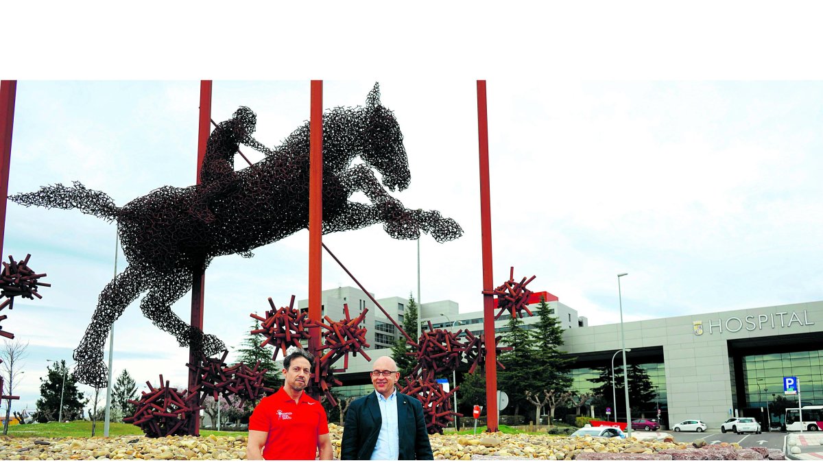 Sergio Muela, fisioterapeuta, y Óscar Gómez Ferrero, delegado provincial del Colegio de Fisioterapeutas de Castilla y León, frente al monumento al covid. J. NOTARIO