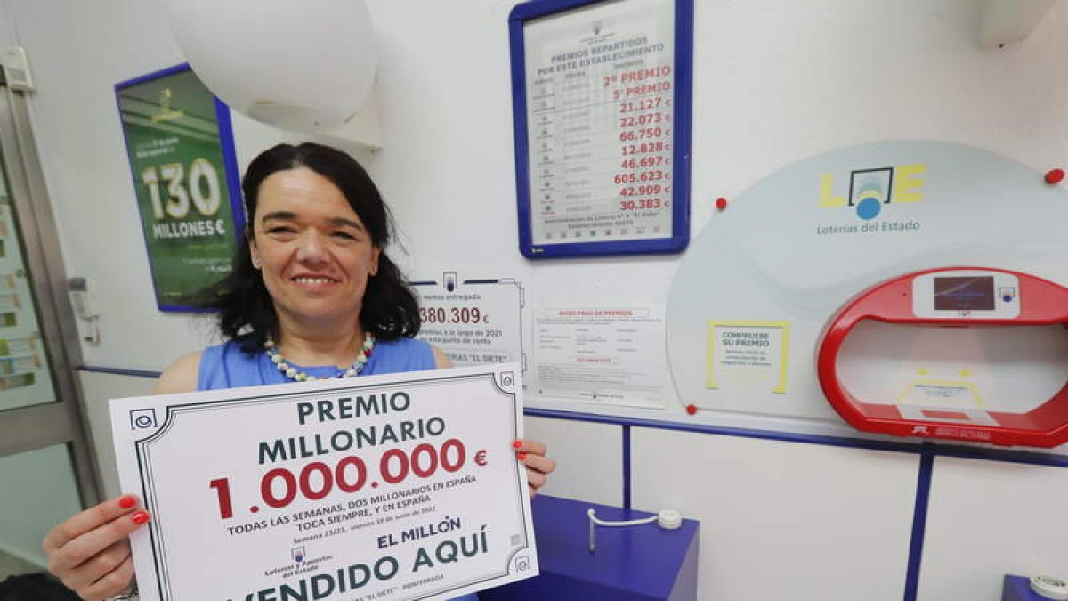 La lotera Rebeca Blanco posa con el cartel del premio. L. DE LA MATA