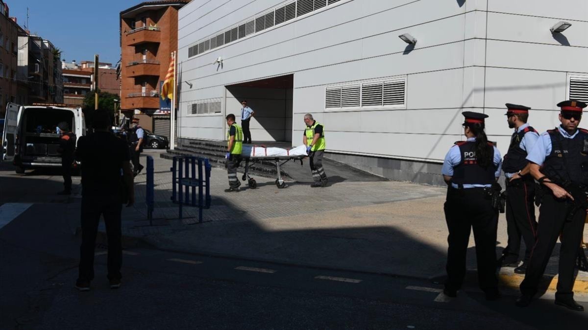 Miembros de la funeraria judicial retiran el cadáver del agresor de la comisaría de los Mossos en Cornellà
