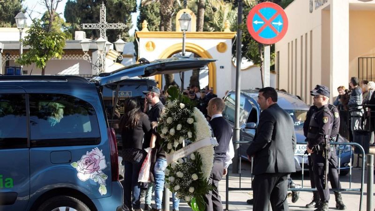 Servicios funerarios portan coronas de flores en el tanatorio de la barriada malagueña de El Palo.