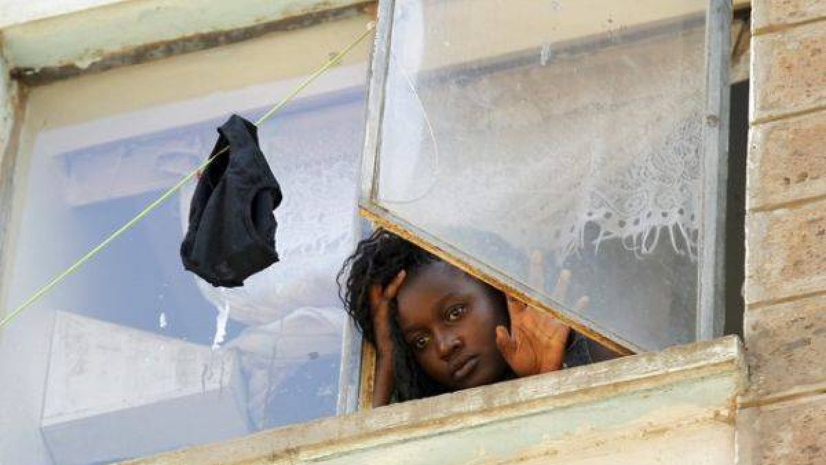 Una estudiante mira a través de una ventana en la residencia de mujeres del campus de Kikuyu, en Nairobi.
