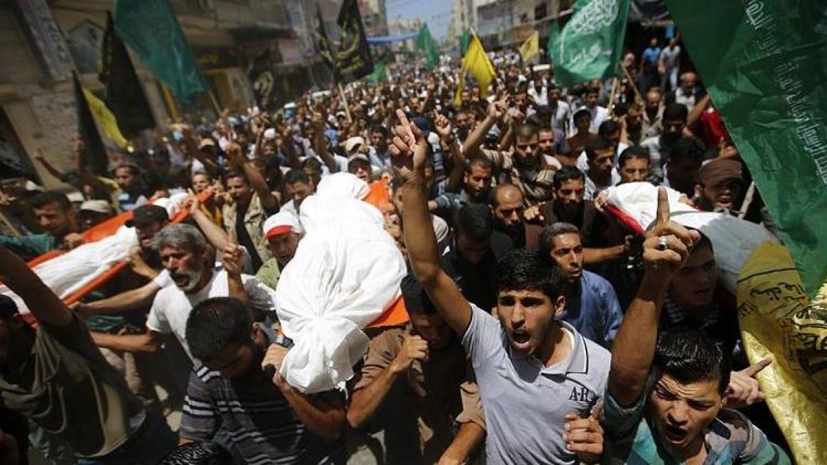 Varios palestinos portan los cuerpos sin vida de cuatro miembros de la familia Al Astal durante el funeral celebrado en un campo de refugiados de Khanyounis, al sur de la Franja de Gaza.