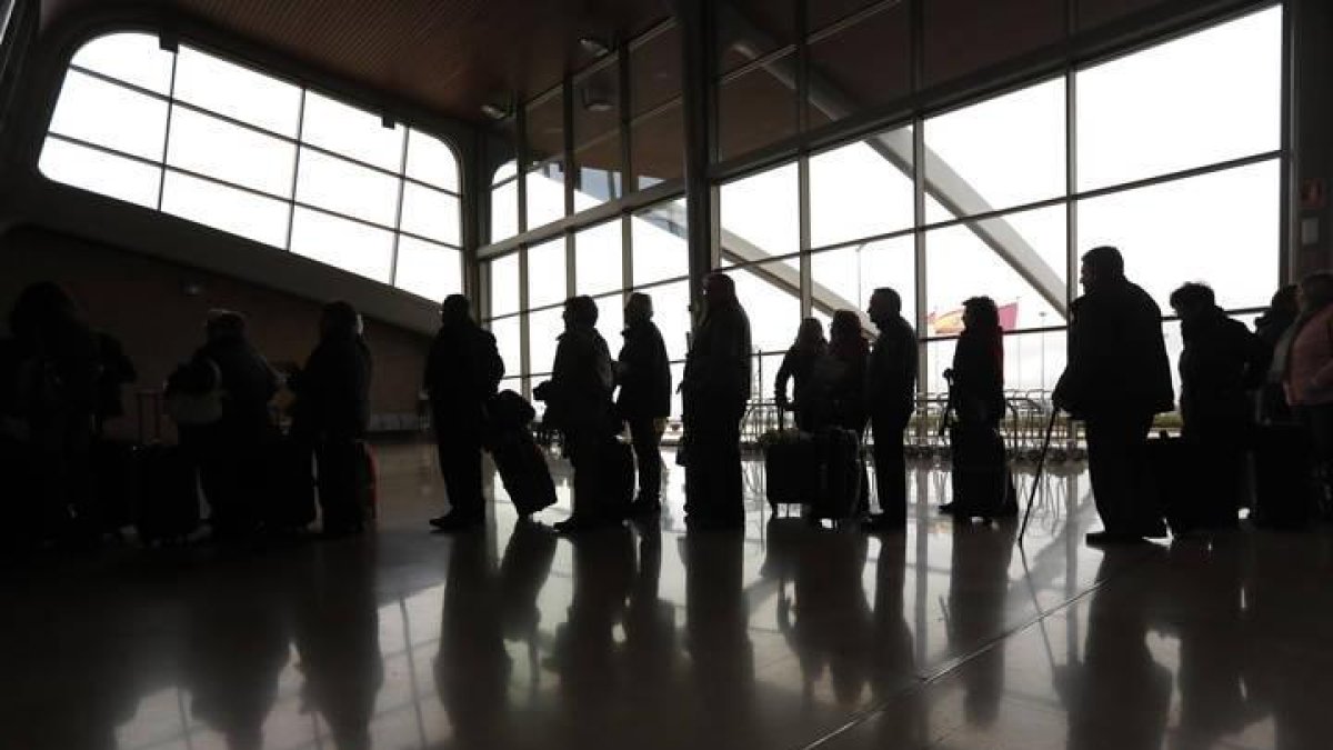 Los pasajeros hacen cola para facturar sus equipajes en el aeropuerto de León.