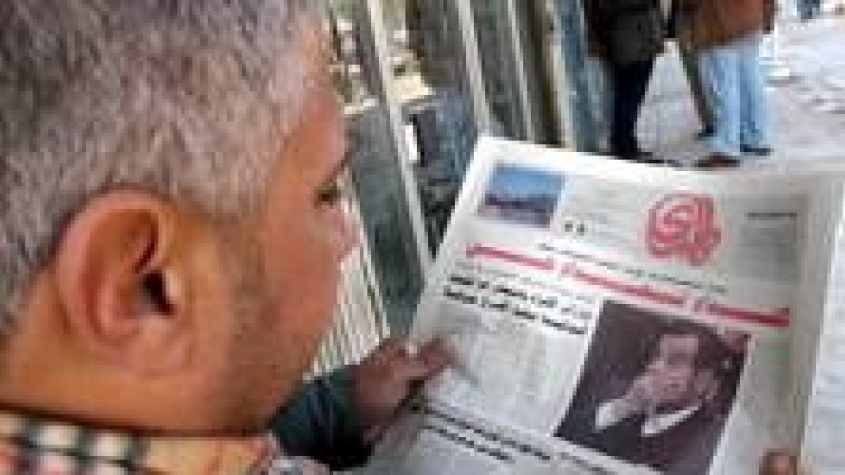 Un iraquí lee en un periódico en Bagdad la noticia sobre la sentencia de Sadam Huseín a muerte