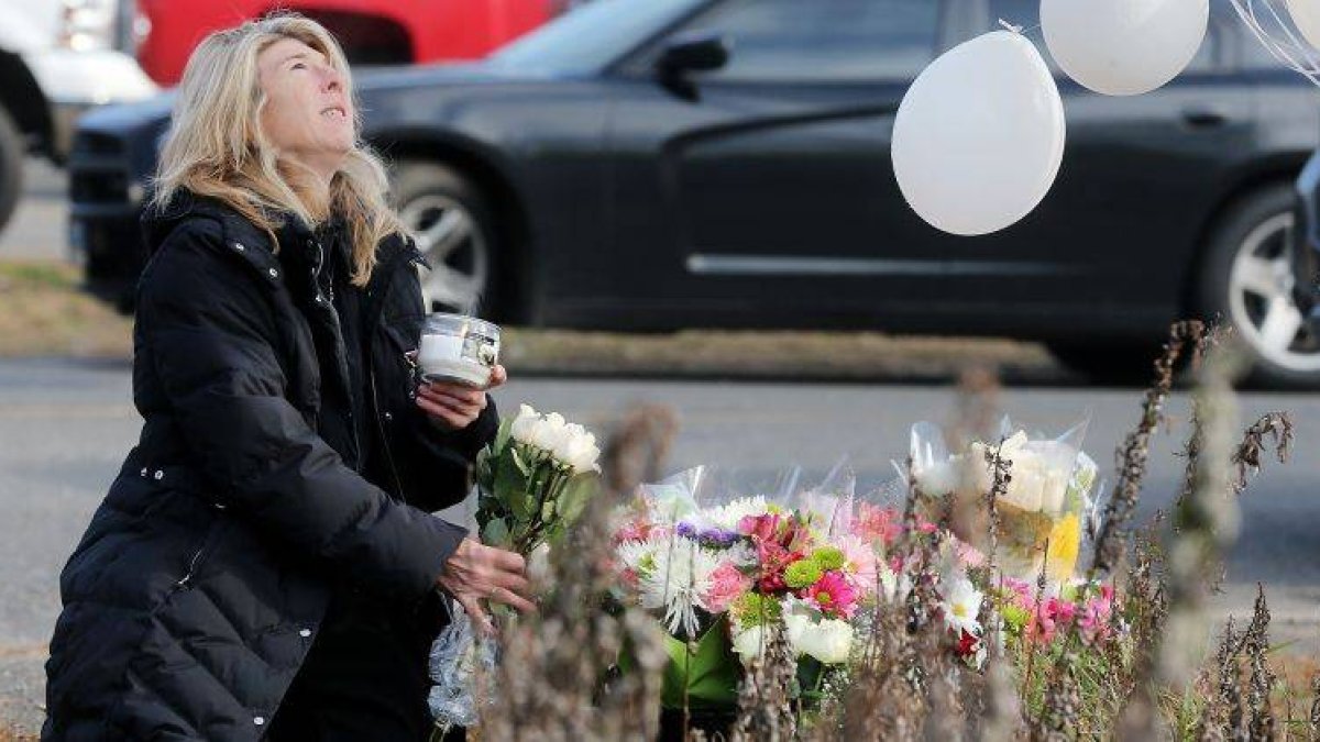 Una mujer deposita flores en el lugar del homenaje a las víctimas de la matanza.