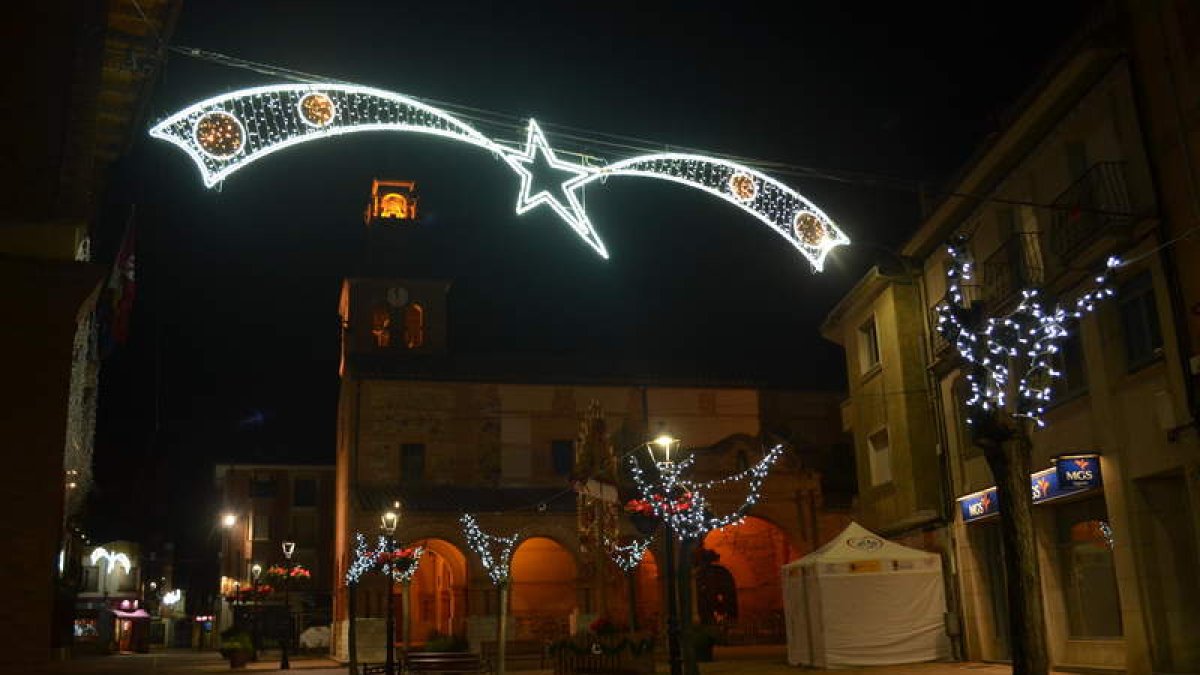 Imagen del centro de Santa María del Páramo iluminado para Navidad con la iglesia la fondo.