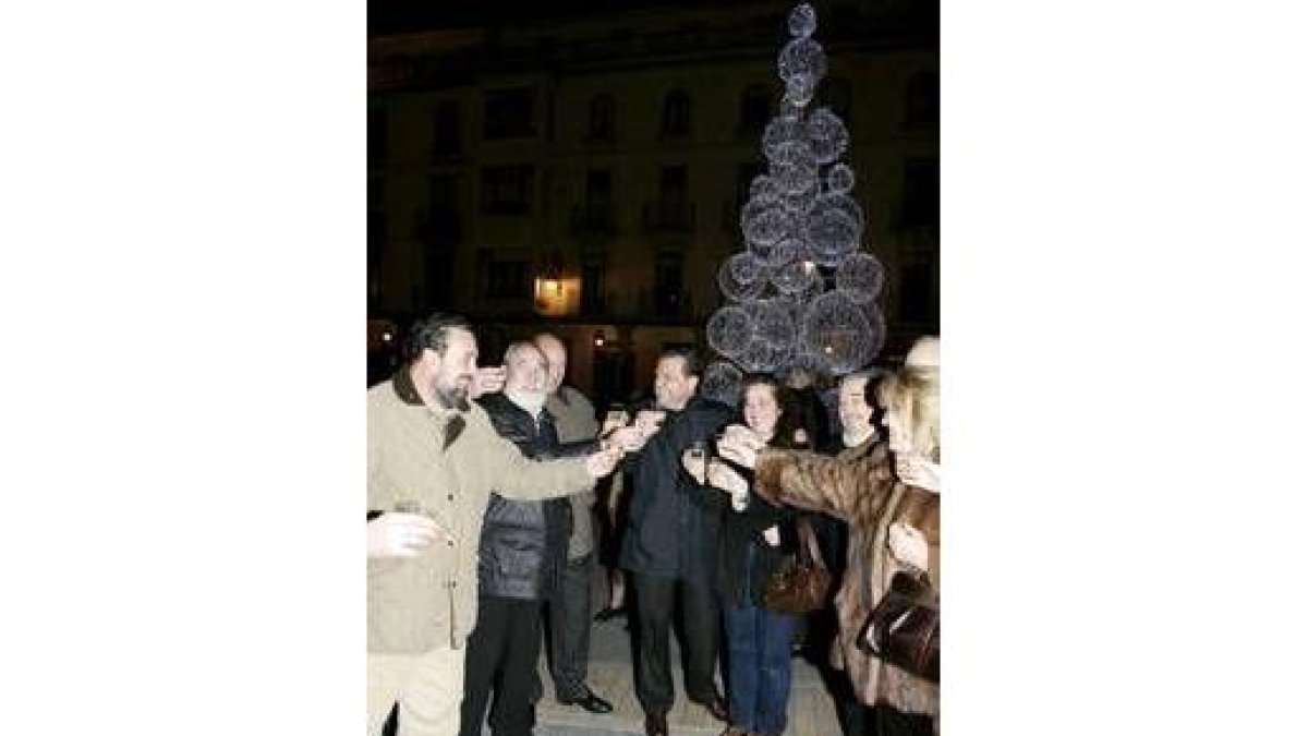 Mario Amilivia, en el centro, brinda por unas felices fiestas con el árbol iluminado detrás